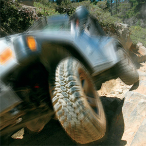 Off-road vehicle climbing a pile of rocks.