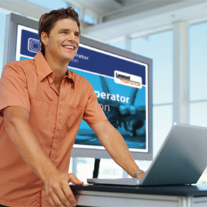 Man standing in front of a laptop smiling.